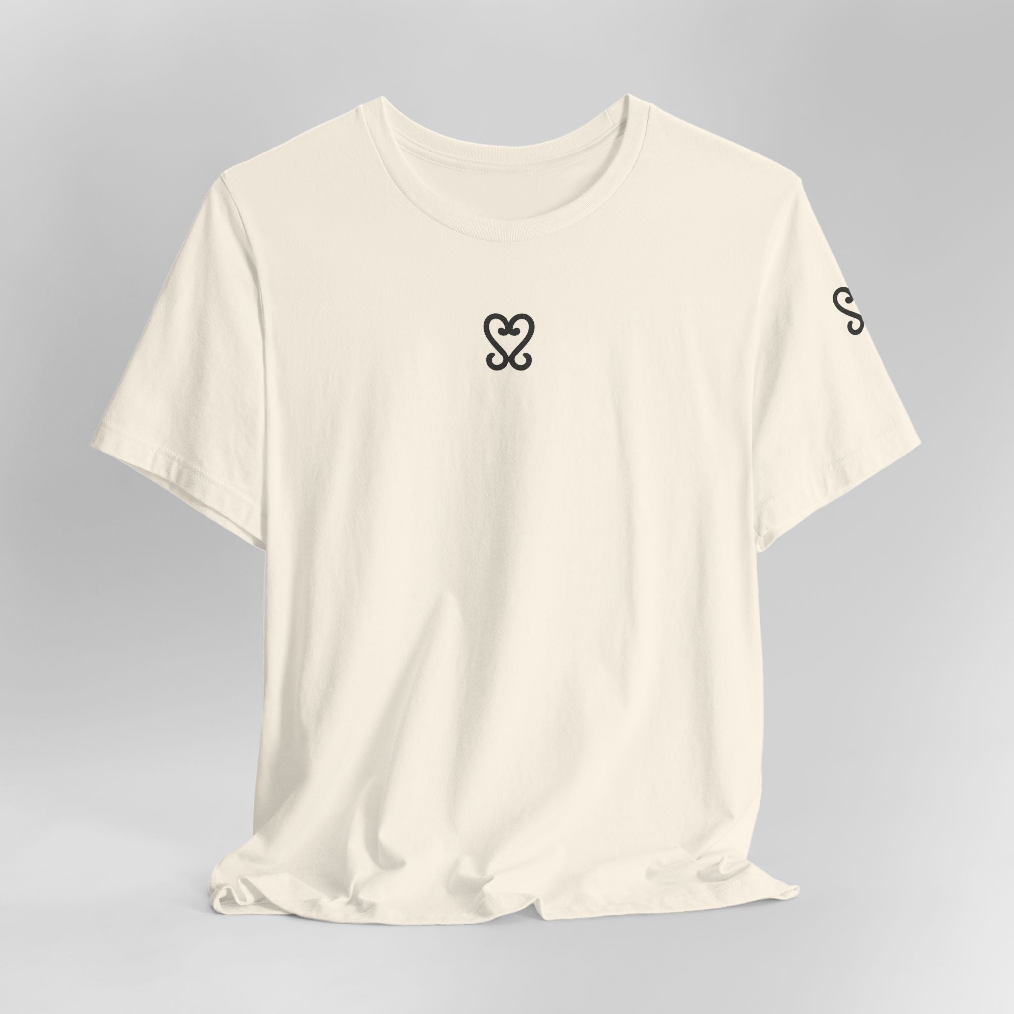 Beige t-shirt with black heart and circle design on a gray background