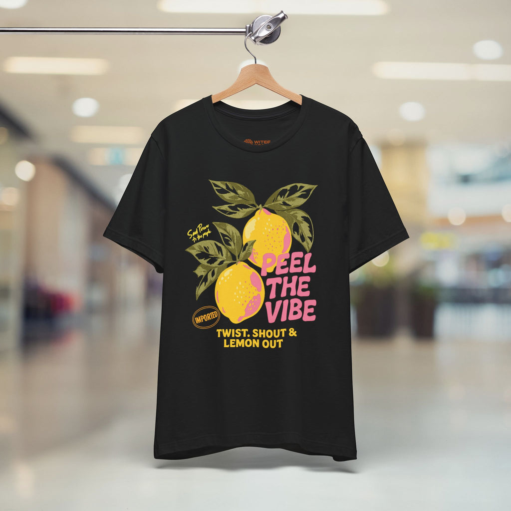 Black t-shirt with lemon graphic and text on a hanger in a store.