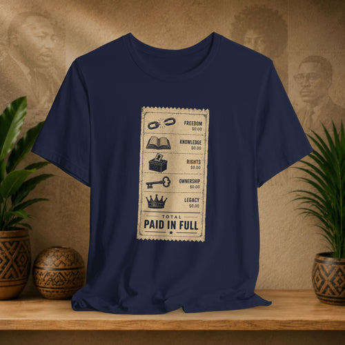 Navy blue t-shirt with a graphic design on a wooden surface with plants and decorative items.