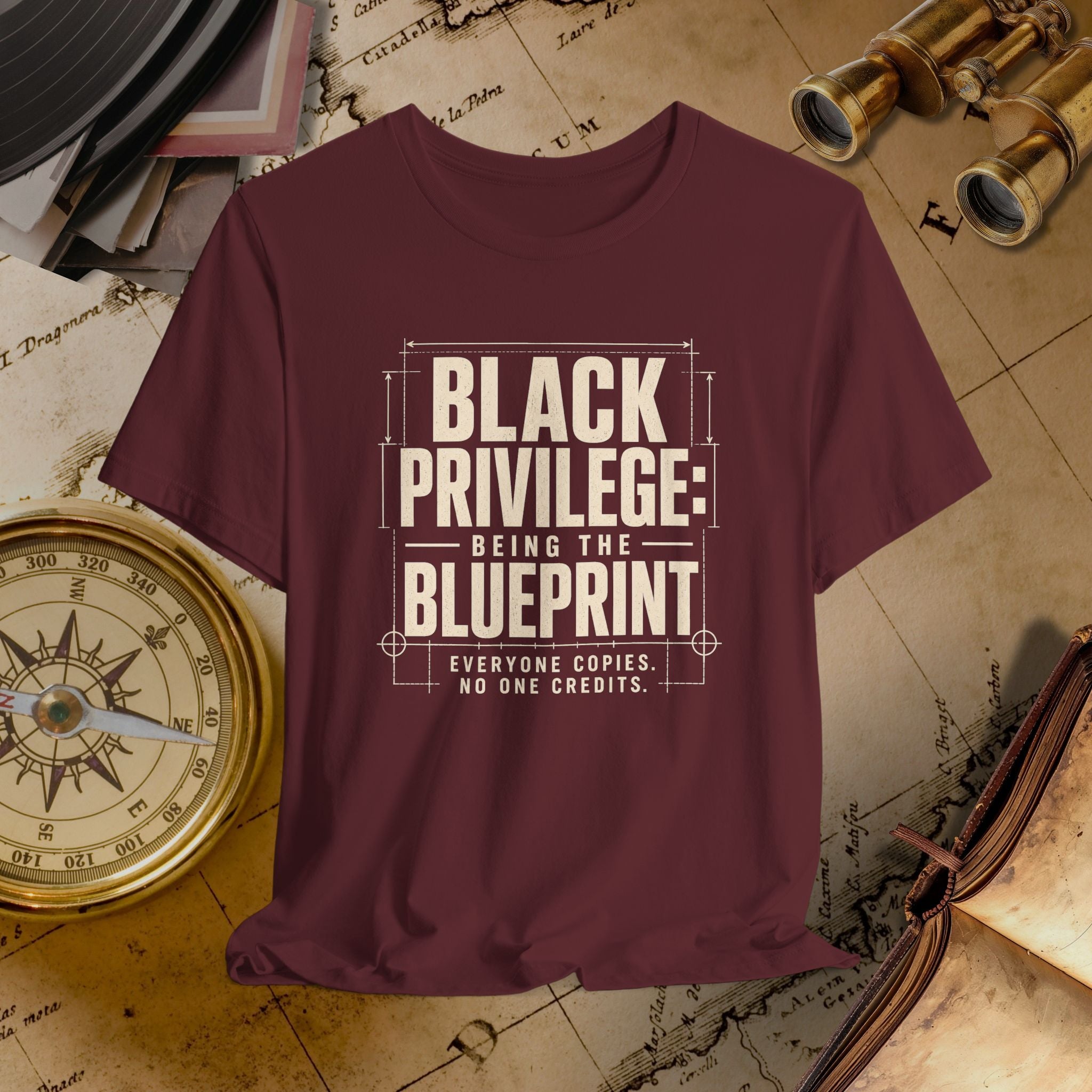 Maroon t-shirt with 'Black Privilege: Being the Blueprint' text on a vintage map background.