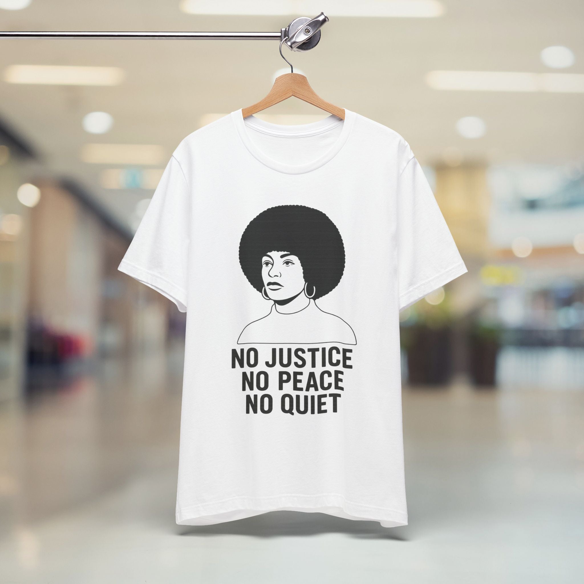 White t-shirt with graphic and text on a hanger in a store setting