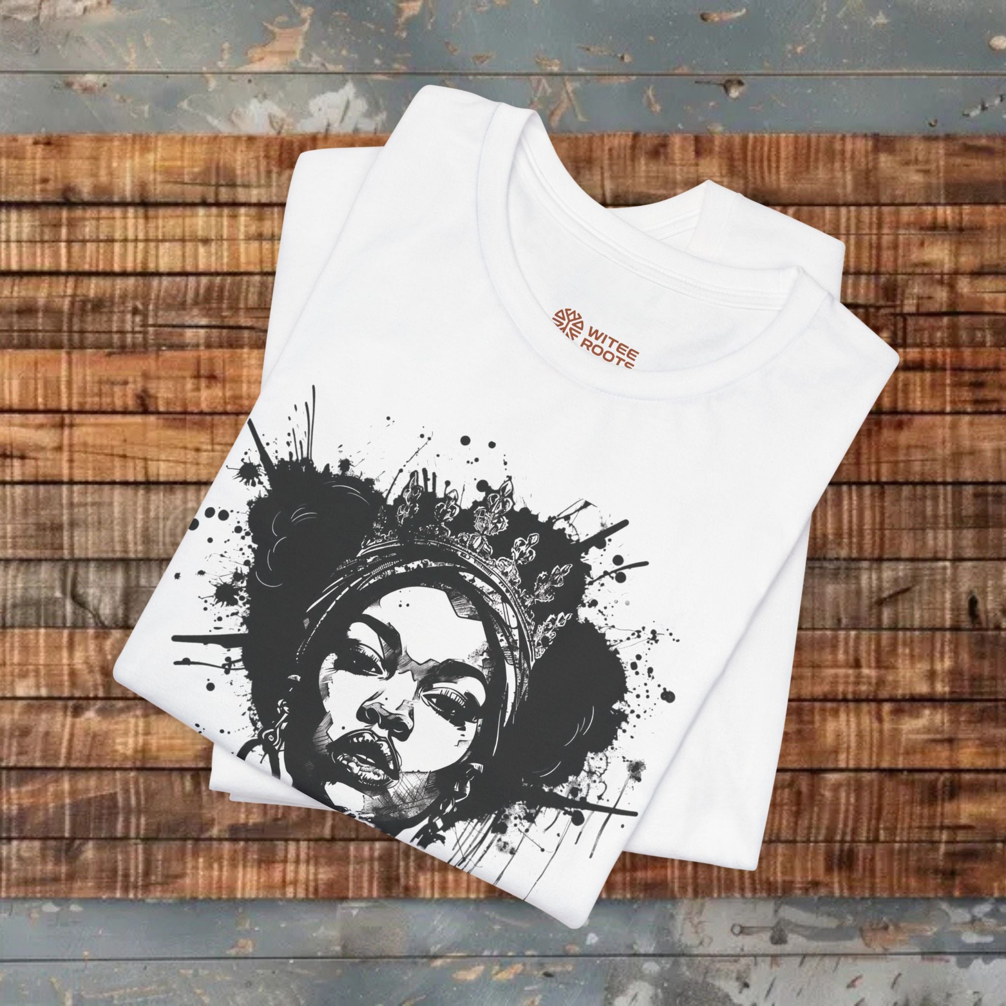 White t-shirt with black graphic design on a wooden surface