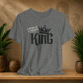 Light grey Lineage of Legends King graphic tee with black crown design, displayed on a shelf with plants and Afrocentric portraits