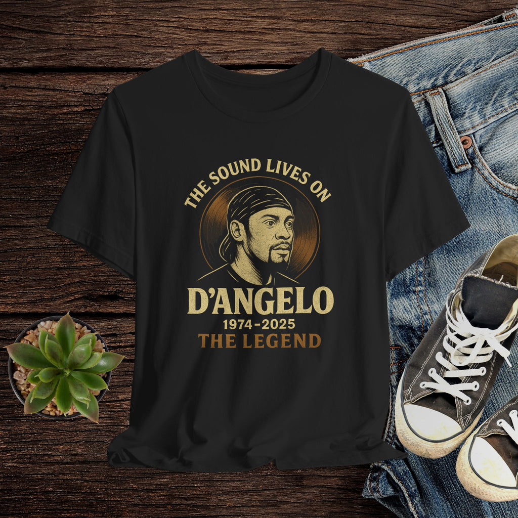 Black t-shirt with D'Angelo graphic design on a wooden surface with jeans and sneakers.