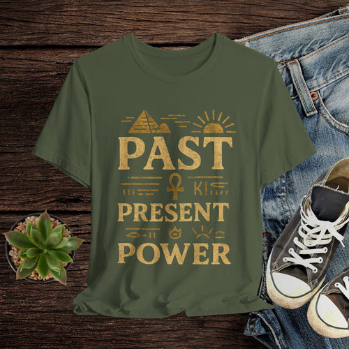 Green t-shirt with gold text on a wooden surface with jeans and shoes.