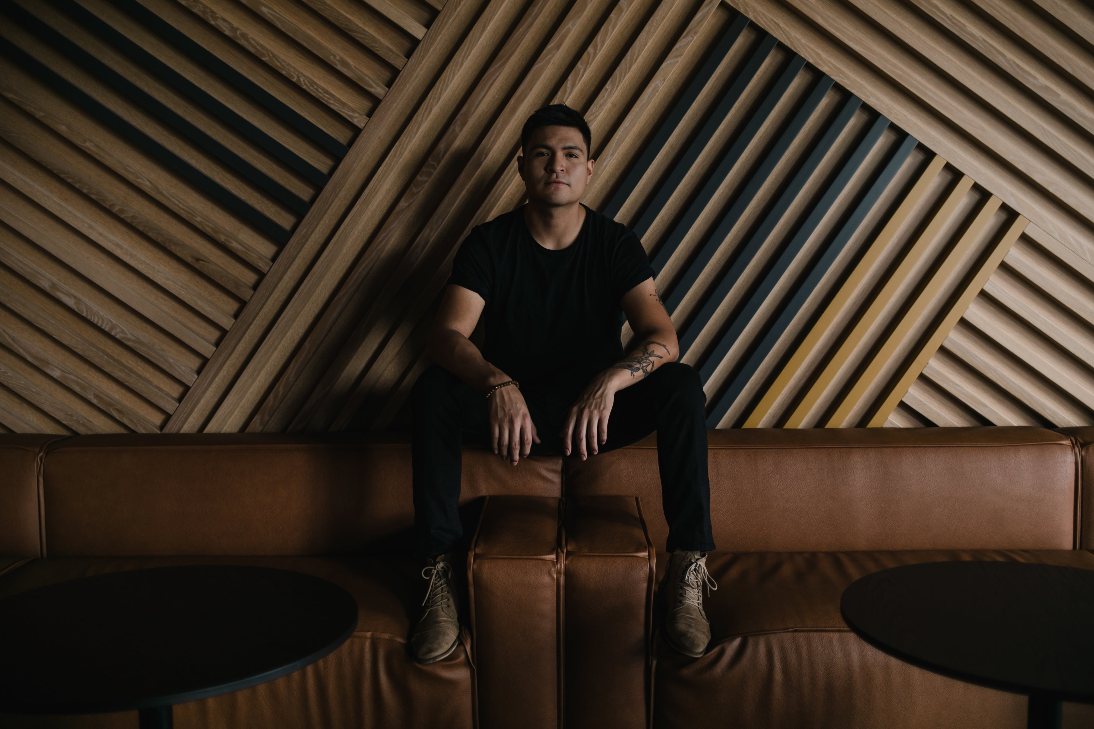 portrait-of-young-man-against-large-geometric-wood-wall